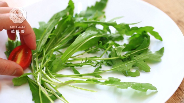 圣女果切半，与芝麻菜一起放在盘中